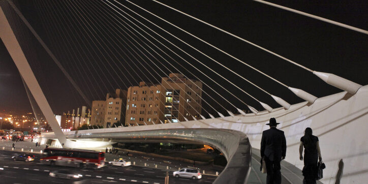 Ulrta orthodox jewish couple walks on the Harp bridge at night in Jerusalem